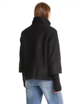 Tapado de tejido boucle color verde oscuro, con silueta evasé y largo a la cadera. Presenta cuello alto envolvente, cierre frontal con botones a presión ocultos y bolsillos frontales de gran tamaño. Cuenta con mangas 3/4 de corte amplio y puños de tejido rib al tono que se extienden para cubrir las muñecas.