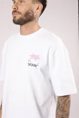 Remera blanca de algodón con cuello redondo, corte holgado y estampado pequeño en el frente.