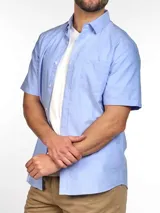 Camisa rosa claro de corte clásico con mangas cortas, cuello abotonado y bolsillo en el pecho.