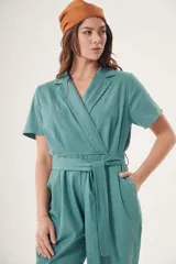 Mono celeste de corte cruzado con cuello camisero, mangas cortas, bolsillos laterales y cinturón de lazo.