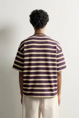 Camiseta de corte relaxed fit con diseño de rayas horizontales en tonos morado, amarillo y blanco. Presenta cuello redondo y mangas cortas.