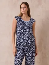 Conjunto de pijama marca René Rofé, compuesto por una remera de escote en V con botones y un pantalón capri con cintura elastizada, ambos en tejido soft estampado con motivos florales en tonos celeste y blanco.