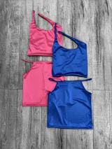 Conjunto de dos piezas compuesto por un top y una pollera de satén. El top presenta un diseño de un solo hombro, mientras que la pollera cuenta con un corte recto y tiro alto. Disponible en colores fucsia y azul eléctrico.
