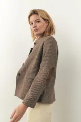 Chaqueta corta con cuello solapa, manga larga con coderas aplicadas, cierre frontal con botones y bolsillos ojal. Con forro.