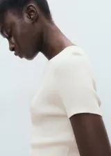 Jersey de punto fino canalé, color blanco, de manga corta y cuello redondo, con diseño recto y ajustado al cuerpo.