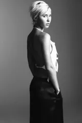 Top blanco de cuello halter y hombros descubiertos, con detalle de lazos en el delantero y cierre en la espalda con tira ajustable.