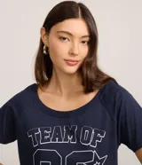 Remera de algodón azul marino con cuello redondo y mangas cortas. Presenta un diseño gráfico en el frente con el texto 'TEAM OF 92' y detalles de estrellas estampadas en contorno blanco.