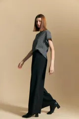 Pantalón ancho color marrón, de silueta moderna y calce cómodo, con diseño limpio y fluido. Presenta cierre frontal con botón y cordones ajustables en la cintura.