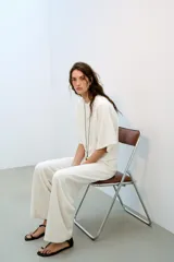 Pantalón rústico color marrón oscuro, de tiro alto, con cintura elástica y cordón ajustable, y pierna ancha.