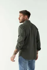 Camisa de hombre color beige con efecto stone wash, corte regular, cuello clásico, cierre frontal con botones, dos bolsillos con solapa abotonada en el pecho y mangas largas con puños abotonados.