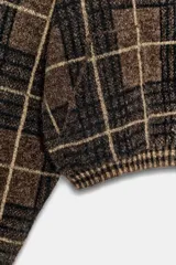 Chaqueta tipo bomber confeccionada en tejido de punto con estampado de cuadros en tonos marrones y negros. Presenta cuello solapa con detalle de pelo sintético a contraste, cierre frontal con cremallera metálica y puños y bajo acanalados.
