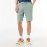 Bermuda de felpa ligera color verde suave, con cintura elástica y bolsillos laterales, de corte cómodo y diseño liso.