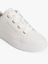 Zapatillas de corte bajo Tommy Hilfiger, confeccionadas en piel napa blanca con paneles de textura contrastante en el talón. Presentan suela gruesa de goma, cierre con cordones y logo metálico en bajo relieve en el lateral.