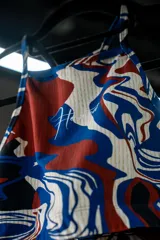 Top deportivo con estampado abstracto en tonos rojo, azul y blanco.