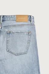 Jeans regular fit confeccionados en denim de algodón celeste con efecto lavado, de cinco bolsillos y cierre frontal con cremallera y botón.