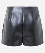 Short pollera de tiro alto confeccionado en poliuretano con acabado que imita el cuero. Presenta un diseño cruzado tipo falda con cinturón integrado de hebilla metálica y cierre oculto.