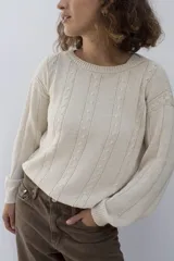 Sweater color crema con cuello redondo y diseño de ochos en el frente, tejido artesanalmente en hilado 70% algodón y 30% acrílico.