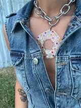 Collar con cadena gruesa plateada y dije abstracto de acrílico y resina color blanco. El dije es desmontable.