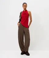 Pantalón de sastrería modelo barrel, color marrón, con tiro medio, cintura con pasantes, cierre frontal, bolsillos posteriores embutidos y recortes frontales estructurados.