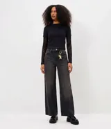 Blusa femenina estilo baby look de color negro, con diseño de superposición que combina una remera de manga corta con mangas largas de encaje transparente. Confeccionada en una mezcla de algodón y poliéster con elastano.
