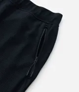Pantalón deportivo de corte ajustado, confeccionado en tejido de poliéster texturizado color negro. Presenta cintura elástica con cordón de ajuste, bolsillos laterales con cierre y puños elásticos en los tobillos.