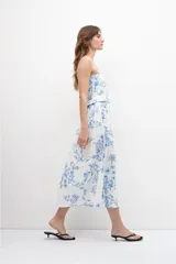 Vestido midi strapless con estampa floral azul sobre fondo blanco, con cinturón.