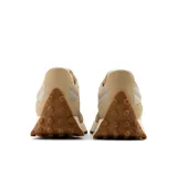 Championes New Balance modelo 327 color beige, con detalles en gamuza y malla, logo "N" en los laterales y suela de goma con diseño texturizado.