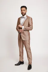 Traje de tres piezas color bronce con acabado satinado, compuesto por saco entallado, pantalón de vestir y chaleco con solapas estampadas en tonos grisáceos. Incluye moño a juego.