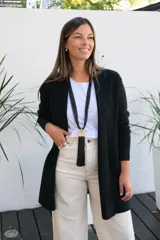 Saco abierto de punto color negro, con mangas largas y bolsillos frontales. Diseño de corte recto y largo medio.