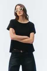 Remera negra de corte evasé y largo corto, con escote redondo y mangas cortas.