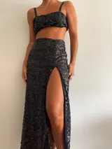 Pollera larga negra cubierta de lentejuelas, con tajo lateral alto.