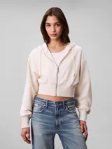 Buzo cropped con capucha y cierre frontal de Calvin Klein, confeccionado en punto milano. Presenta mangas largas con puños acanalados, dobladillo inferior también acanalado y cordones ajustables en la capucha.