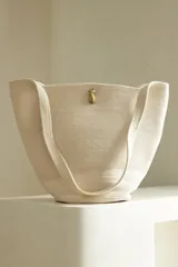 Bolso tipo tote confeccionado en soga de algodón color crudo, con cierre de broche dorado.
