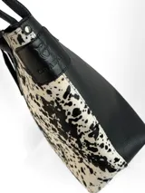 Cartera tipo tote de cuero genuino color marrón oscuro con textura de reptil. Cuenta con doble asa de hombro, cierre superior y un dije colgante de cuero a tono.