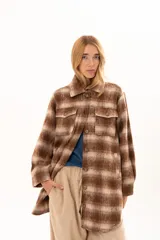 Chaqueta de textura suave y afelpada con diseño de rayas horizontales en tonos beige y marrón. Presenta cuello camisero, cierre frontal con botones y mangas largas con puños abotonados.