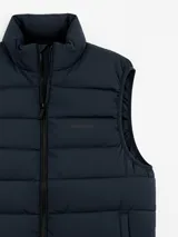 Chaleco acolchado de color azul marino, con cierre frontal completo y cuello alto. Presenta un diseño de costuras horizontales y logo bordado en el pecho.