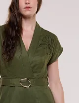 Enterito largo de lino verde militar con escote en V cruzado, mangas cortas japonesas, cintura entallada con cinturón y hebilla metálica, y pantalón de corte recto con bolsillos laterales.