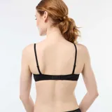 Sujetador balconet negro de encaje con aros y tirantes regulables.