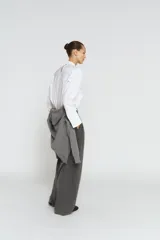 Pantalón de tiro medio con pinzas frontales, confeccionado en tejido con viscosa. Presenta cintura con trabillas, bolsillos laterales y cierre frontal con cremallera, botón y ganchos metálicos.