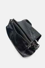 Bolso de hombro negro con detalle de costuras y tres compartimentos, uno con cierre de cremallera. Asa de hombro con cadena y cierre mediante imán.