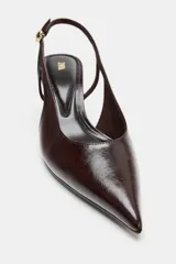 Zapato destalonado de tacón ancho, con tira trasera ajustable mediante hebilla metálica y diseño de punta fina.