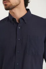 Camisa de manga larga con cuello abotonado y bolsillo frontal, confeccionada en una mezcla de algodón y lino.