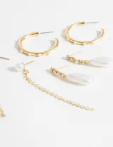 Set de tres pares de aros dorados con detalles de perlas. Incluye un par de aros tipo argolla, un par con dije de perla colgante y un par con cadena colgante.