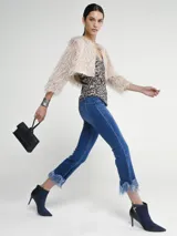 Saco corto color beige con plumas.