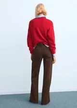 Jeans de corte recto y tiro medio color marrón, con diseño clásico de cinco bolsillos y cierre frontal con botón y cremallera.