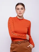 Top negro de manga larga con cuello alto y aberturas en los brazos.