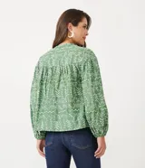 Blusa tipo bata de algodón con tejido laise bordado, cuello redondo con cordones y borlas, y mangas largas abullonadas con puños ajustados.
