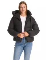 Campera puffer de corte recto y acabado mate, con diseño de bloques horizontales acolchados. Presenta capucha integrada con cordones de ajuste, cierre frontal metálico y bolsillos laterales invisibles. Incluye puños elásticos internos para mayor protección contra el frío.