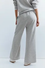 Pantalón deportivo gris claro de corte ancho, con cintura elástica y bolsillos laterales.