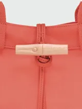 Bolso tipo shopper de gran tamaño, color caqui, con cierre de broche de madera y tira de cuero ajustable. Cuenta con doble asa de mano y diseño minimalista.